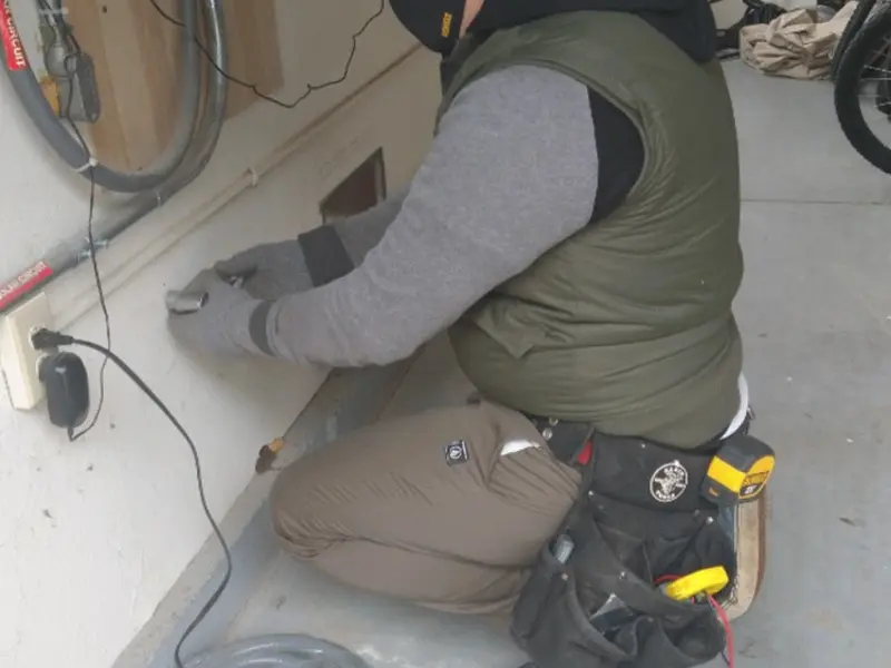 Electrician performing outlet wiring in a Mount Morris garage